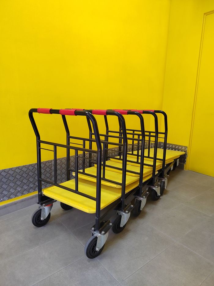 pexels-photo-29640307 Multiple industrial dollies lined up in a vibrant yellow room.
